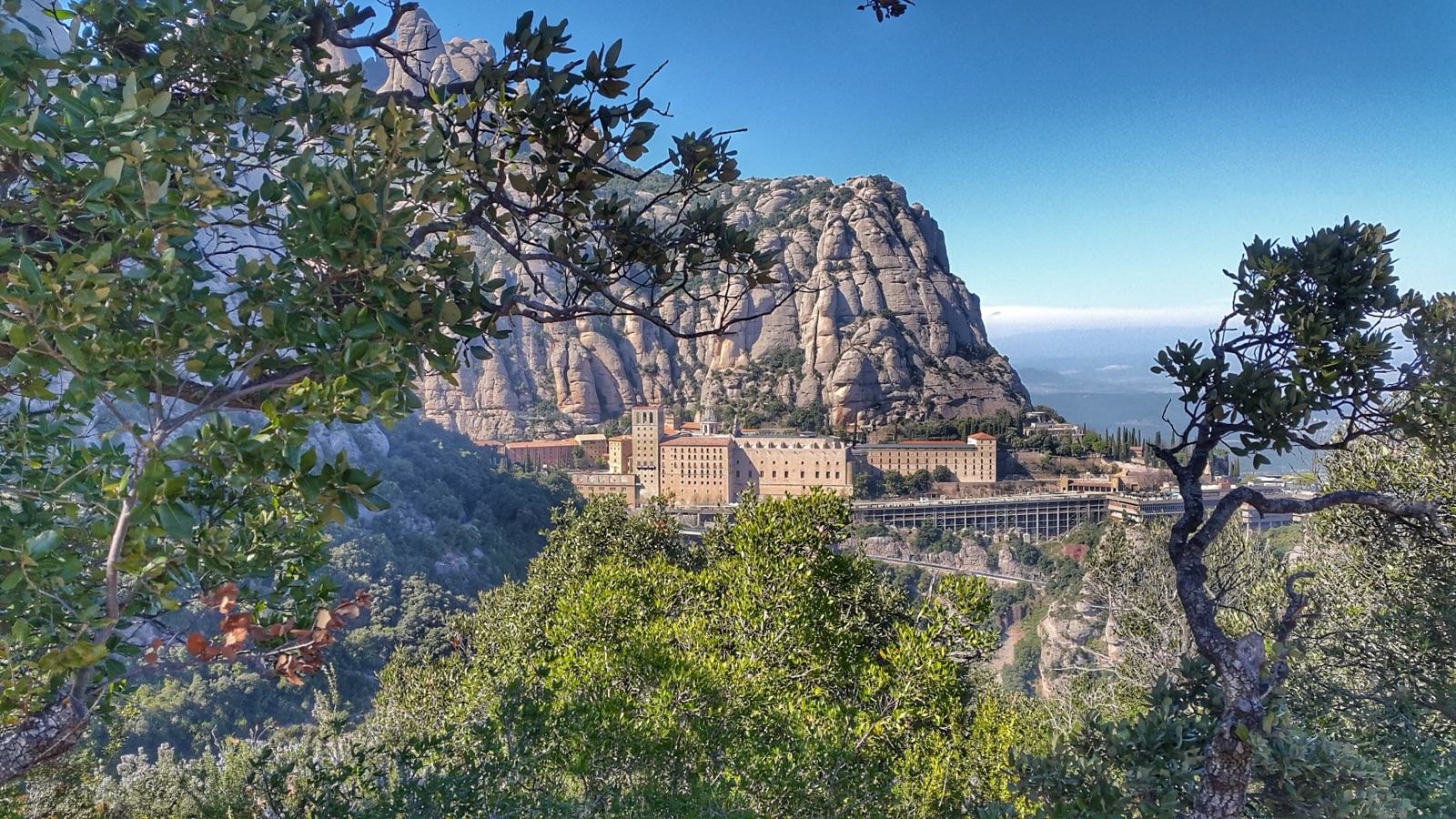 Santa Maria de Montserrat monastery below the serrated rock pillars of the Montserrat massif